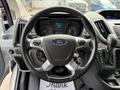 Steering wheel of a 2017 Ford Transit with controls and logo visible in the center