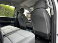 Interior view of a 2024 Ford F-550 showing front and rear seats with gray fabric upholstery and a center console between the front seats