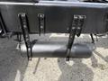 A black air tank mounted under a truck chassis secured with metal brackets and bolts