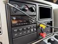 The dashboard of a 2016 International 7600 featuring controls for climate and audio system along with various buttons for vehicle functions