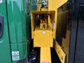 A yellow control box mounted on the side of a vehicle with various hoses and machinery components visible inside
