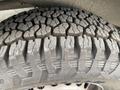 A close-up view of a rugged tire with a deep tread pattern designed for an all-terrain vehicle
