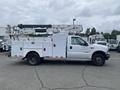A white 2003 Ford F-450 SD with a utility body and an elevated work platform on the rear