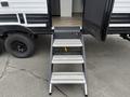 A set of three gray and silver steps leading up to the entrance of a 2022 Keystone Hideout RDWE 20RDWE travel trailer