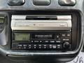 A 2003 Mitsubishi Delica dashboard with a car stereo featuring a cassette player and radio controls