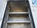 Interior of a 2004 Freightliner M2 truck with metal shelves inside a storage compartment