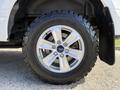 A close-up of a chrome alloy wheel on a 2018 Ford F-150 with an all-terrain tire showing tread patterns and the Ford logo on the center cap