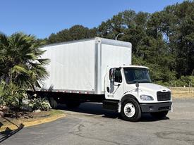 A 2015 Freightliner M2 106 box truck in white with a spacious cargo area and a cab designed for commercial transportation