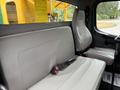 Interior of a 2015 Freightliner M2 106 showing a gray bench seat with seatbelts and a driver's seat in a truck cab