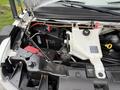 Engine compartment of a 2020 Chevrolet Express showing the battery coolant reservoir and various hoses and connectors