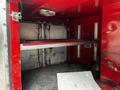 Interior view of a 1991 Sutphen Deluge fire truck compartment with a metal shelf and a bell visible