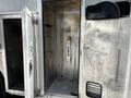 An open side door of a 2008 Morgan Olson Workhorse revealing a metallic interior with an enclosed compartment and a vertical handle on the rear wall