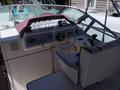 A 1991 Larson Mirado boat interior featuring a steering wheel dashboard with gauges and controls along with a white captain's seat