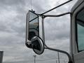 A silver side mirror attached to a 2016 Peterbilt 348 truck with a chrome finish showing a clear reflection of its surroundings