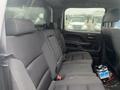 Interior view of the back seat of a 2015 GMC Sierra 1500 featuring black fabric upholstery and a center armrest