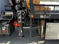 Close-up of a 2012 Freightliner M2 112 truck featuring hydraulic equipment and storage compartments on its side