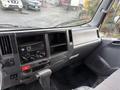 Interior view of a 2015 Isuzu NPR HD dashboard featuring a radio, various controls and a gear shifter