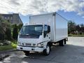 A 2007 GMC W5500 18 foot cube van with a white cargo box and orange clearance lights on the roof