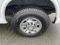 Close-up of a chrome wheel with a Firestone tire on a 2014 Chevrolet Express showing detailed tread and hubcap design