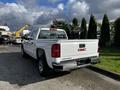 A white 2017 GMC Sierra 1500 pickup truck parked with a visible tailgate and GMC logo