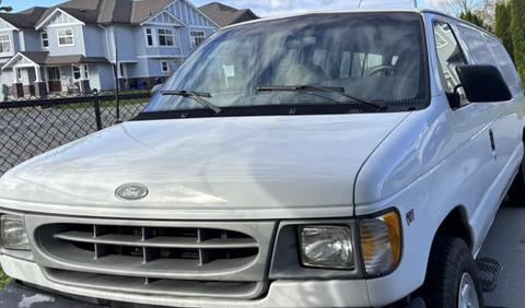 A white 2002 Ford Econoline van with a prominent front grille and large headlights