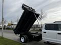 A 2021 Ford F-550 dump truck with its bed raised for unloading materials