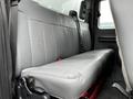 Interior view of a 2013 Ford F-650 showing a silver-gray vinyl bench seat with seat belts in the rear cabin area