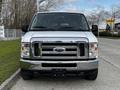 Front view of a 2014 Ford Econoline van with a shiny chrome grille and large headlights