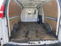 The interior of a 2022 GMC Savana cargo van with wooden panels and a wooden floor showing wheel wells on either side