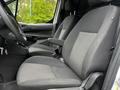 Interior of a 2016 Ford Transit Connect showing two front seats with gray fabric upholstery and a steering wheel visible behind them