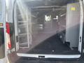 Interior of a 2016 Ford Transit van showing empty cargo space with metal shelving on one side and a compartment on the other
