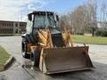 A 2005 Case 570 tractor with a front loader attachment facing forward and large tires