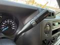 Close-up of the gear shift lever of a 2023 Ford E-450 featuring buttons for gear selection and a black ergonomic design