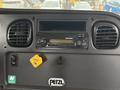 Dashboard of a 2015 Freightliner M2 106 featuring a car radio and various control dials with a yellow parking brake tag visible