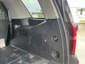 Interior view of a 2016 Chevrolet Tahoe showcasing the storage area with a latch and ventilation grill