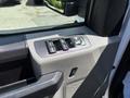 Interior control panel of a 2016 Ford F-150 featuring window switches and a dial for adjusting mirrors