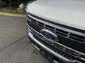 Close-up of the front grille of a 2023 Ford F-550 featuring a chrome finish and the Ford logo prominent in the center with "SUPER DUTY" embossed above