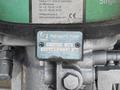 A close-up of a pneumatic pump showing a label with technical details and model information