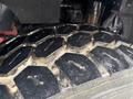 Close-up of a rugged truck tire tread with a hexagonal pattern on a Kenworth T800 showing dirt and wear on the surface