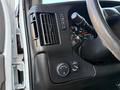 Interior dashboard controls of a 2015 GMC Savana featuring air conditioning vents buttons for vehicle settings and a steering wheel with control levers