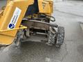 A yellow 2014 Vermeer Corporation Sweep Stump Cutter with a large rotating blade and rugged tires positioned on a wet surface
