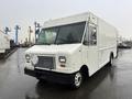A 2012 Ford Econoline delivery van with a white exterior and large front windshield featuring a grille and headlights
