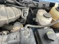 A 2009 Ford Econoline engine compartment showing various components including the air intake and fluid reservoirs