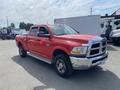 Red 2012 RAM 2500 truck with a double cab and chrome accents parked at an outdoor location