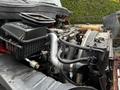 Engine compartment of a 2011 International 4400 displaying various mechanical components including the air filter housing and piping