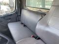 Interior view of a 2017 Freightliner M2 106 showing a gray bench seat with seat belts and a part of the driver's area