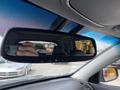 A rearview mirror of a 2015 Kia Sorento showing the reflection of the interior and a hand holding a camera
