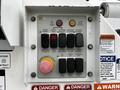 Control panel featuring buttons for operating a boom lift with labeled functions including emergency stop platform controls and unit operation controls