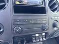 Dashboard of a 2012 Ford F-450 SD showing air conditioning controls and a radio display with various buttons and knobs