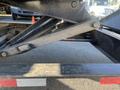 A close-up view of the lifting mechanism of a 2024 Southland 18 Foot Dump Trailer showing hydraulic components and a textured surface of the trailer bed